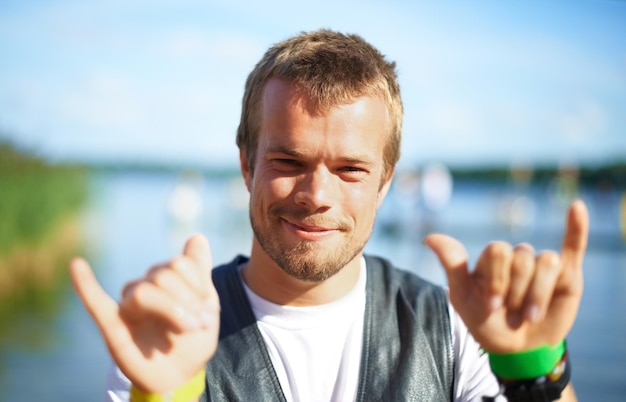 I like to party. Head and shoulders shot of a young man having a good time at an outdoor festival.