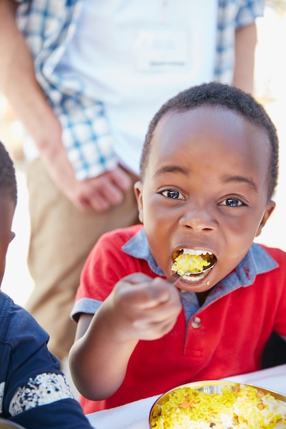 私は食べ物が大好きです食べ物のアウトリーチで餌を与えられている少年のトリミングされた肖像画