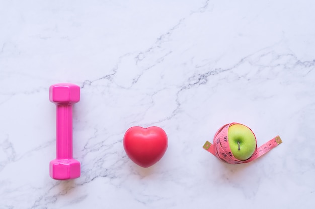 I love healthy food concept, flat lay of pink dumbbell with red heart and green apple 