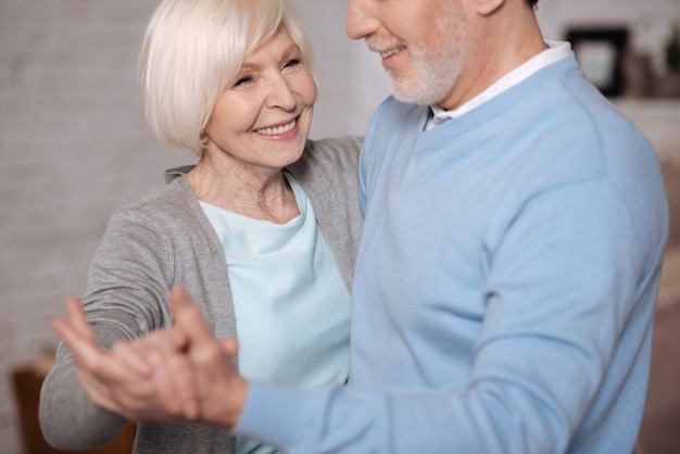 I love him. Close up portrait of happy aged woman smiling while dancing with her husband.