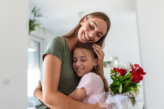 Foto ti amo mamma giovane donna attraente con una bambina carina stanno trascorrendo del tempo insieme a casa ringraziando per la carta fatta a mano con simbolo d'amore e fiori concetto di famiglia felice festa della mamma