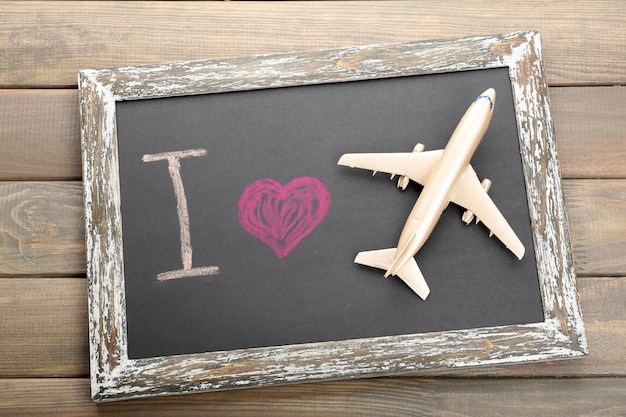 Photo i love travelling by airplane written on chalkboard closeup