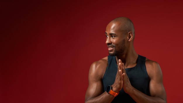 I love yoga young afro american man keeping palms together and looking aside with smile