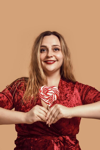 I love you plus size happy woman in velour dress holding a red heartshaped lollipop