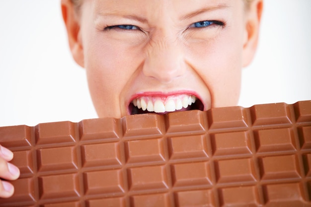 I must eat it all Crazed young woman biting into a huge piece of chocolate