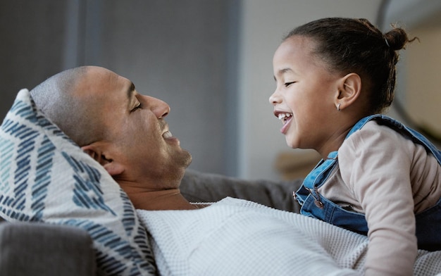 Non mi manca mai l'esterno quando i papà sono a casa scatto di un legame tra padre e figlia mentre giocano sul divano a casa