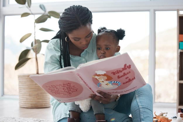 I swear my daughter is a better story teller than me Shot of a woman reading a book to her daughter while sitting at home