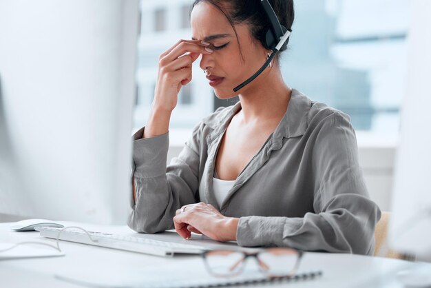 I think I need a break Shot of a young female businesswoman working in a call center with a headache