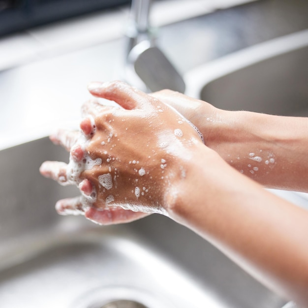 I wash my hands the minute I enter the house Cropped shot of an unrecognizable woman washing her hands in the sink at home