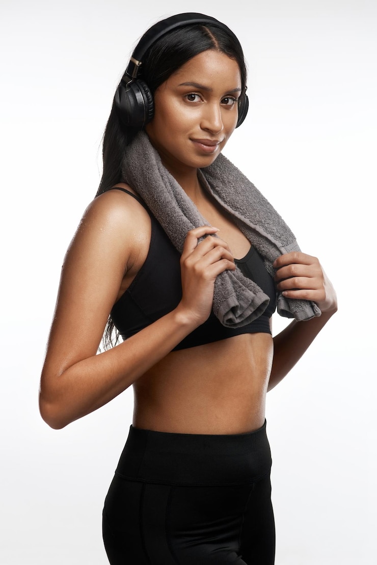 Photo i wont throw in the towel studio portrait of a sporty young woman wearing headphones and holding a towel around her neck against a white background
