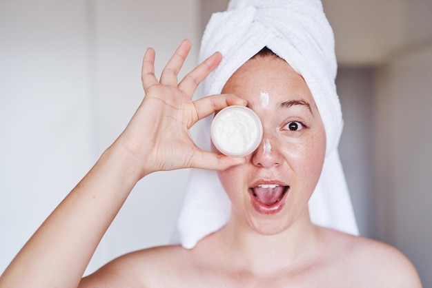 Photo i would like to introduce the best product on the market cropped shot of a beautiful young woman applying moisturizer to her face