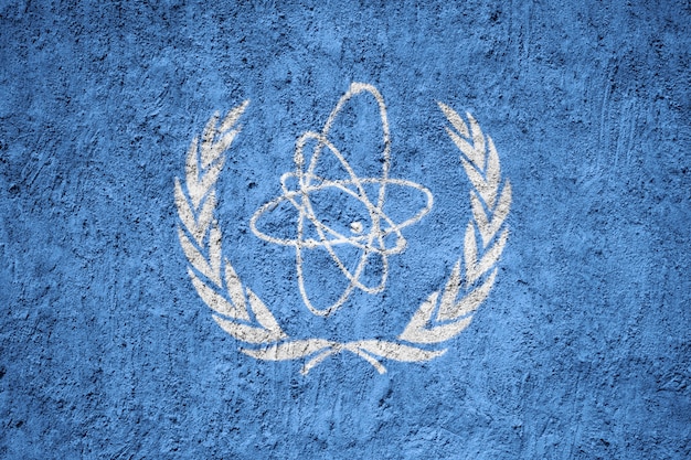 IAEA-vlag op grungemuur die wordt geschilderd