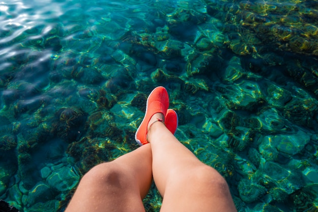 Ibiza girl legs at Portinatx beach clear water