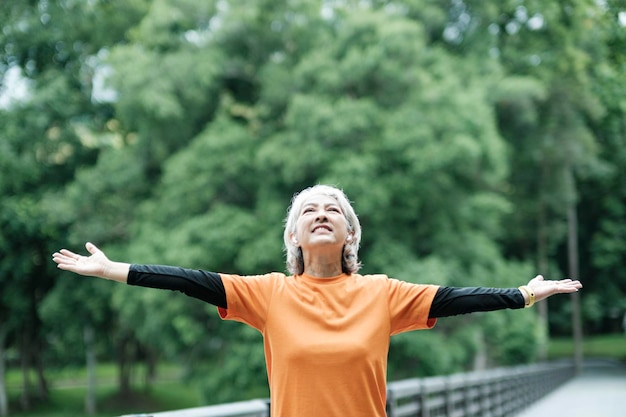 Ic Senior woman stretch arm in park