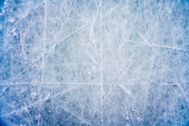 Ice background with marks from skating and hockey, blue texture of rink surface with scratches