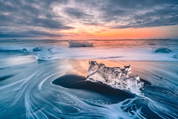 ice at beach against sky during sunset