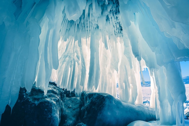 Ice cave with icicles on Baikal lake Winter landscape of Baikal lake Siberia Russia Abstract winter nature background