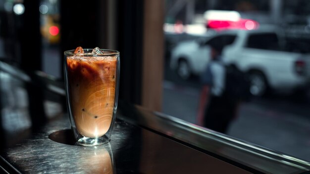 Ice coffee on a table with cream being poured into it showing the texture and refreshing look of the
