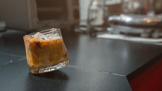 Ice coffee on a table with cream being poured into it showing the texture and refreshing look of the