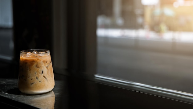 Ice coffee on table with cream being poured into it showing the texture