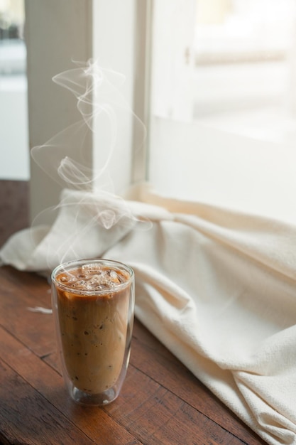 Ice coffee on table with cream being poured into it showing the texture