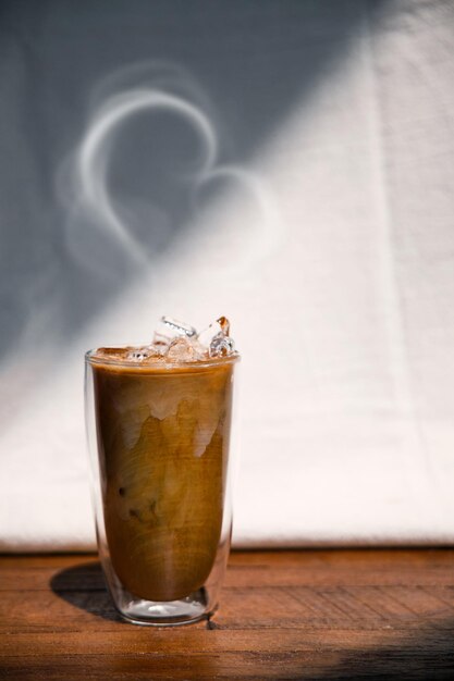 Ice coffee on a table with cream being poured into it showing the texture