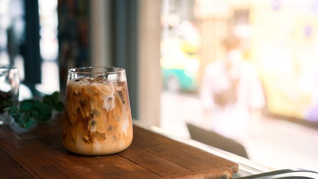 Ice coffee on a table with cream being poured into it showing the texture