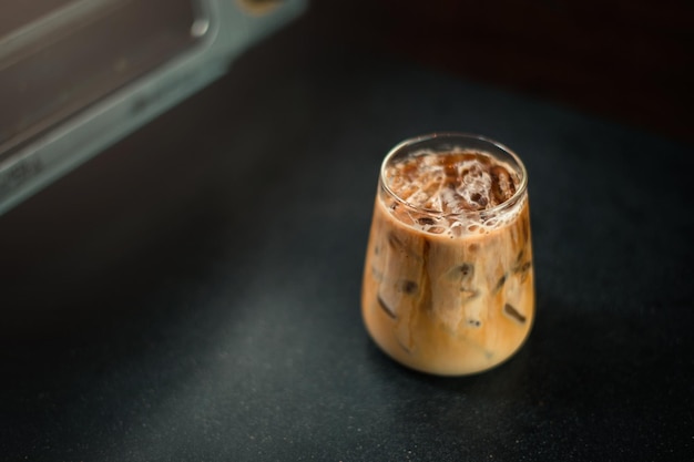 Ice coffee on a table with cream being poured into it showing the texture