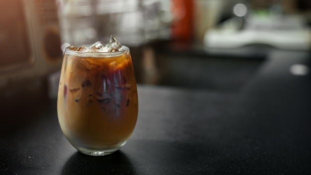 Ice coffee on a table with cream being poured into it showing the texture