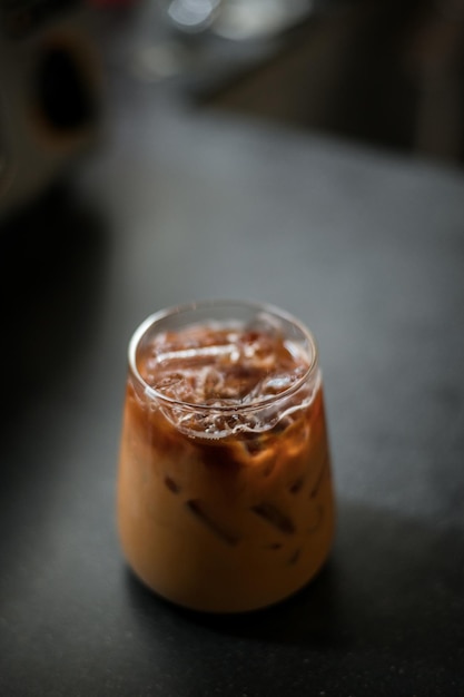 Ice coffee on a table with cream being poured into it showing the texture