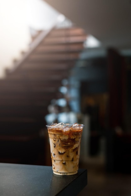 Ice coffee on a table with cream being poured into it showing the texture