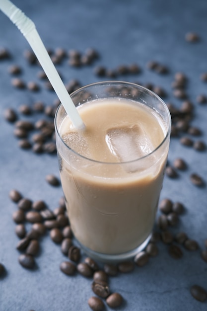 Ice coffee in a tall glass on black background