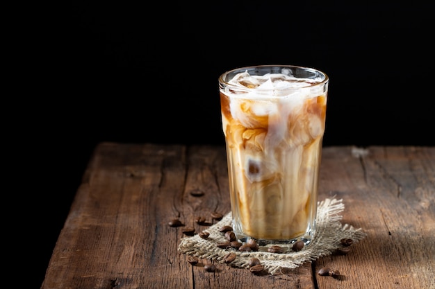 クリーム色の背の高いグラスにアイスコーヒー。