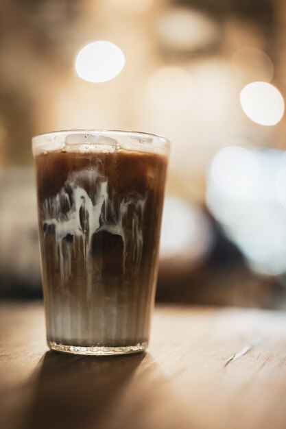 Ice coffee on a wooden background with vintage style concept.