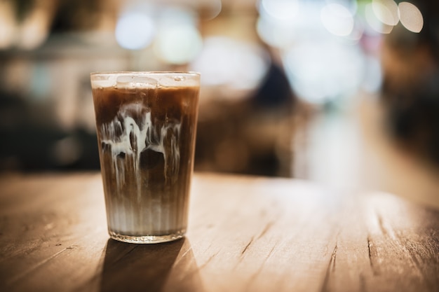 Ice coffee on a wooden background with vintage style concept.