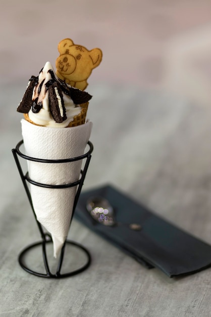 Ice cream cone dessert met cookies creatieve decoratie topping op wazig licht kopie ruimte achtergrond.