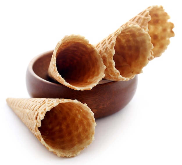 Ice cream cone i wooden bowl over white background