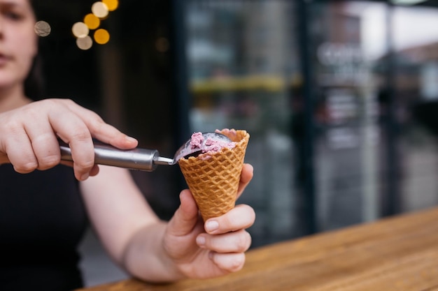 아이스크림 콘 와플 콘이 있는 아이스크림 소녀가 안고 있는 와플 콘 더운 여름이나 겨울에 딱 맞는 생기를 불어넣는 다채로운 시리얼 토핑