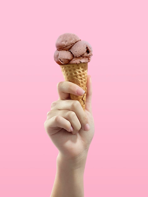 Ice cream cone on pink background woman holding ice cream by hand