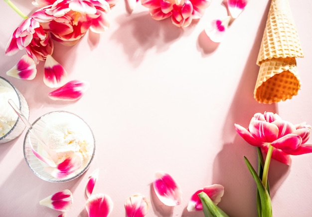 Ice cream cone and sundae with pink flowers and petals summer concept flat lay copy space