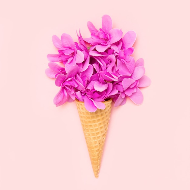 Ice cream cone with flowers on pink