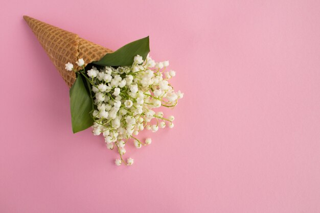 Ice cream cone with lilies of the valley on pink