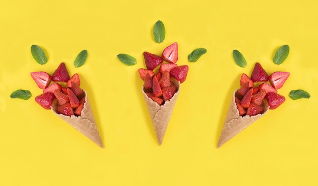 Foto cono gelato con fragola sullo sfondo giallo vista dall'alto primo piano