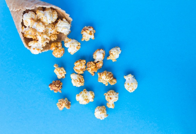 Ice cream cone witn popcorn on the blue background Top view Copy space