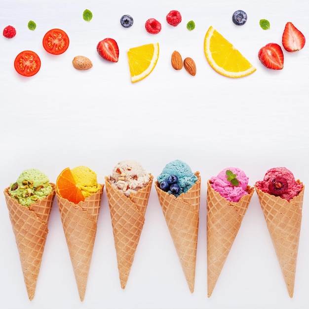 ice cream cones and fruits over white background