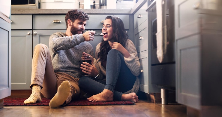 Photo ice cream kitchen and couple on floor in home for bonding relaxing and quality time together love relationship and happy man and woman with sweet treats dessert and luxury snack for romance