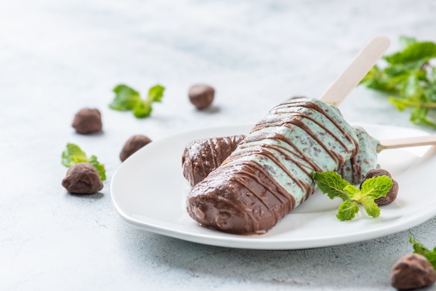 Ice cream mint chocolate chip, bedekt met chocolade stick op plaat. popsicle en lolly zoet dessert.