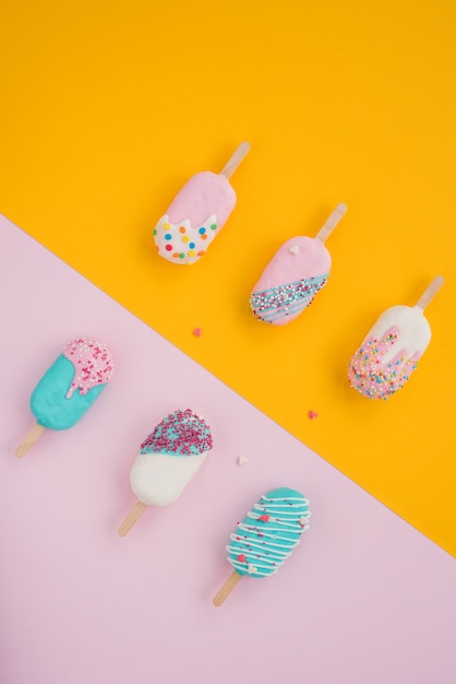 Ice cream popsicle summer concept. Minimal pastel yellow and pink background idea, perpendicular line