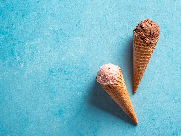 Ice cream scoops in cones with copy space on blue