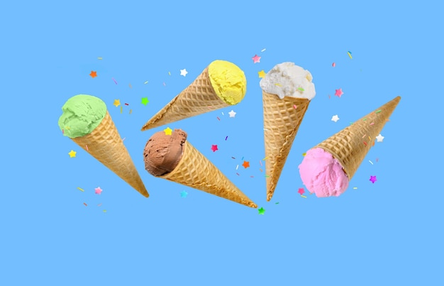 Ice cream scoops in waffle cones with sprinkles flying over blue background Birthday or holiday backdrop